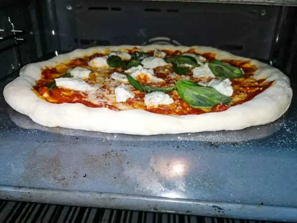 Cooking pizza on the back of a baking tray is one of the best homemade pizza hacks out there!