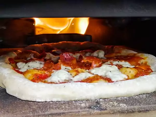 Pizza cooking in a portable pizza oven