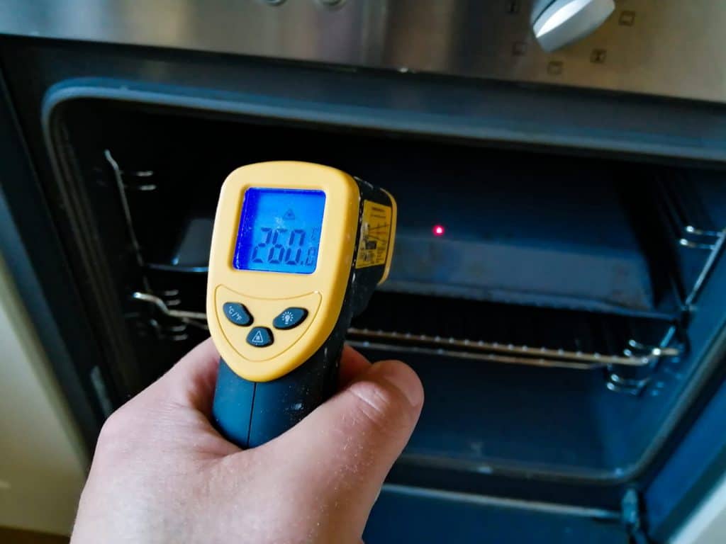 Using an infrared thermometer to measure the temperature of an upside-down baking tray, preheated for 30 minutes