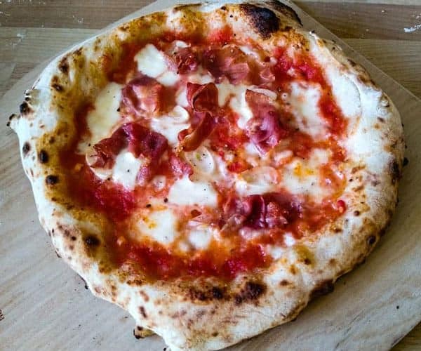 Neapolitan pizza on wooden board with garlic