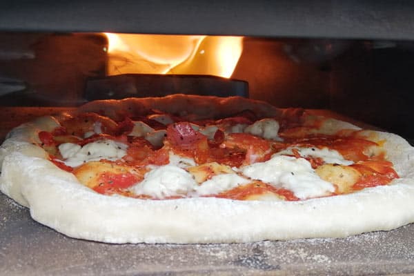 Close up of pizza cooking in pizza oven